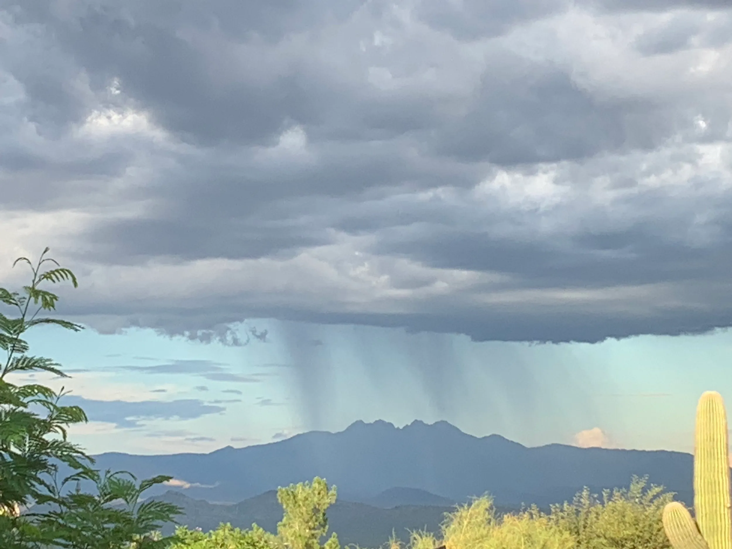 A dramatic storm over a mountain landscape, symbolizing the energetic clearing of a property